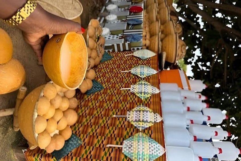 A person pouring a yellow liquid from a jug into a bowl, surrounded by various food items and utensils. 3