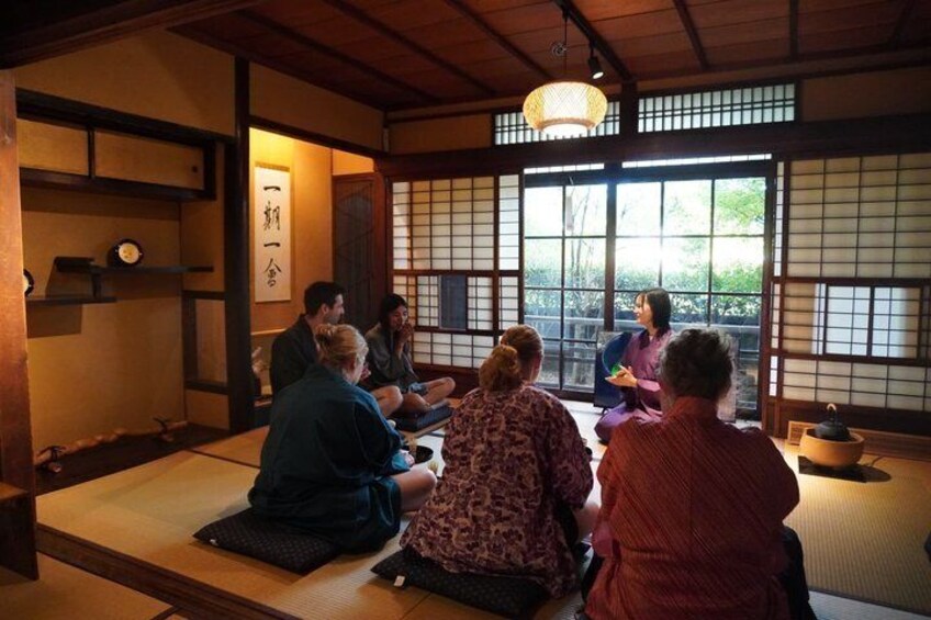 Ett traditionellt japanskt rum med tatamimattor på golvet, skjutdörrar och en hängande lykta. 1