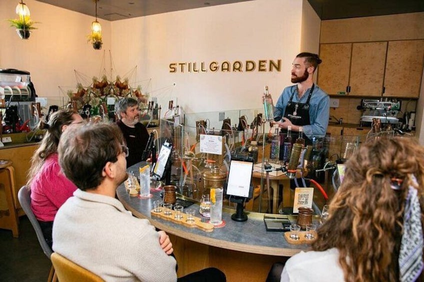 A bar setting with a counter, glasses, and a menu board. 2