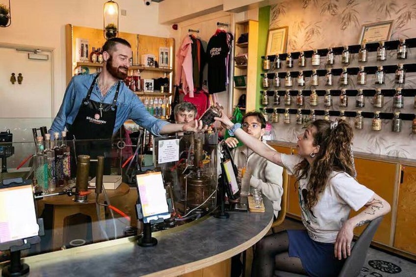 A barista serving coffee to a customer at a counter with a display of various coffee beans and equipment. 1