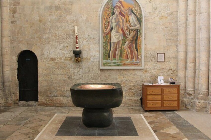 A stone wall with a large painting, a black basin, and a wooden cabinet. 1