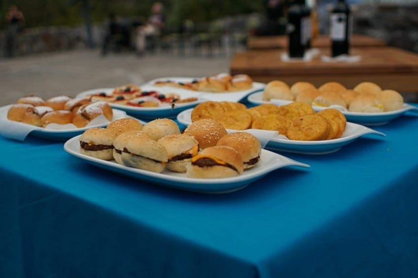 A table with various food items, including sandwiches and pastries, on a blue tablecloth. 3