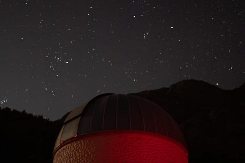 A dome structure with a red base, set against a night sky filled with stars. 4