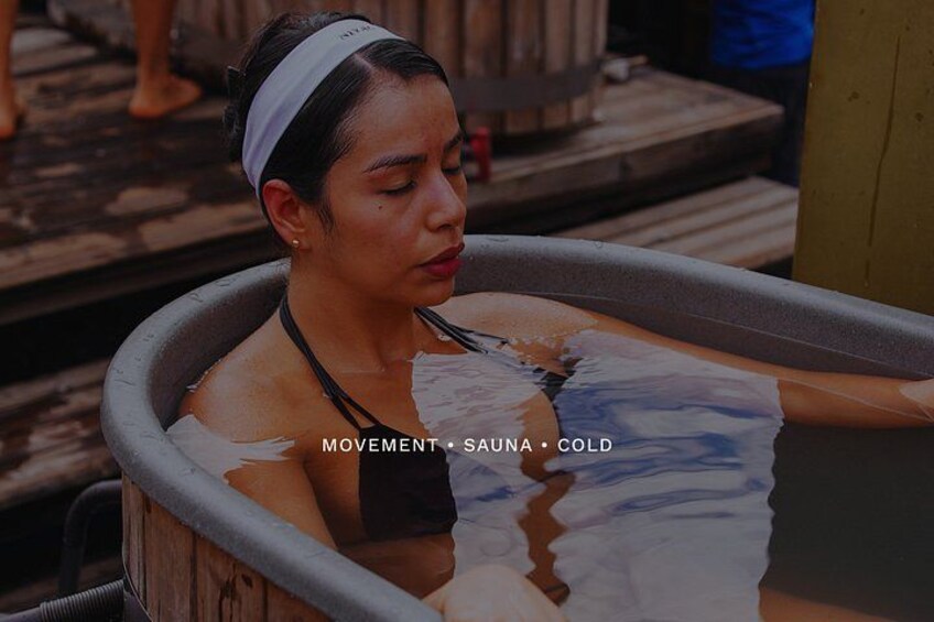 A person in a hot tub with water and a towel. 2
