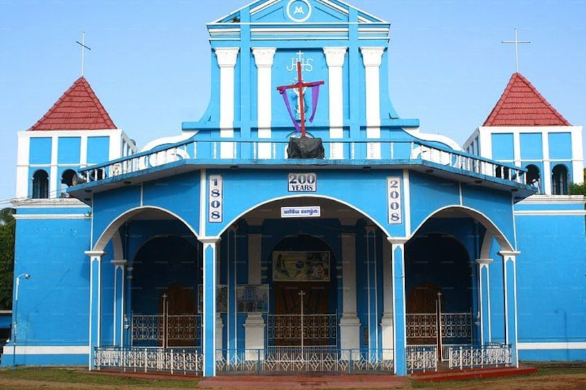 A blue church with a red roof, a cross, and a sign indicating 200 years. 3