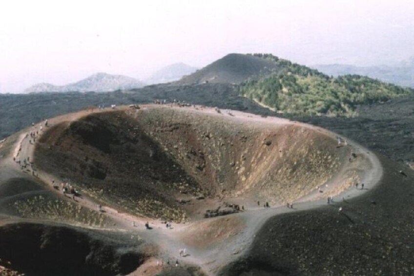 A large, circular crater with a dirt path leading into it. 1