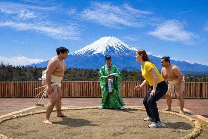 A sumo wrestling match with a backdrop of Mount Fuji. 2
