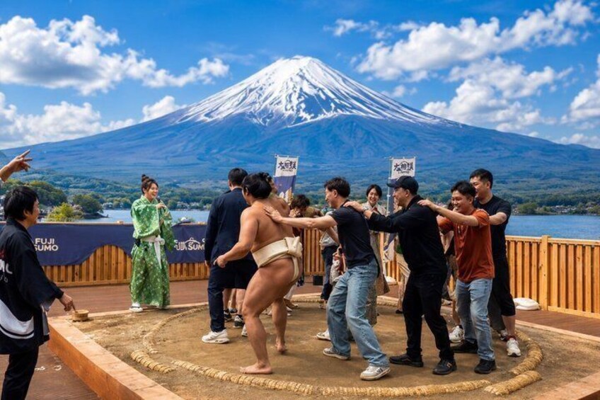 A group performing a traditional dance on a wooden platform with a view of Mount Fuji in the background. 4