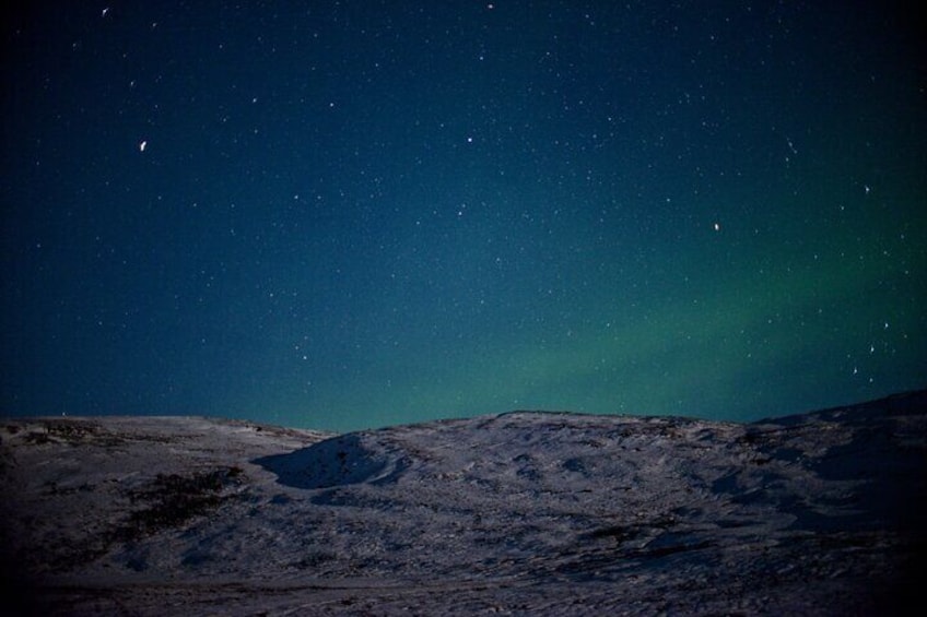 Un paisaje nevado bajo un cielo estrellado con la aurora boreal. 2