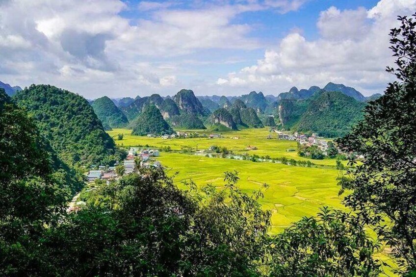 A valley with terraced fields, a small settlement, and a mountain range. 1