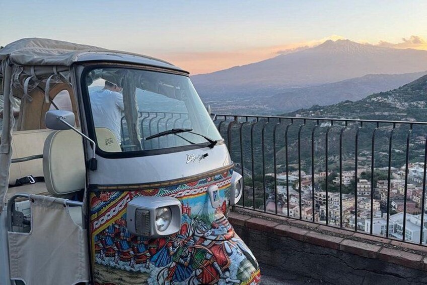 A colorful vehicle parked on a balcony overlooking a mountainous landscape. 1