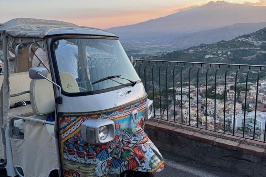 A colorful vehicle parked on a balcony overlooking a mountainous landscape. 4