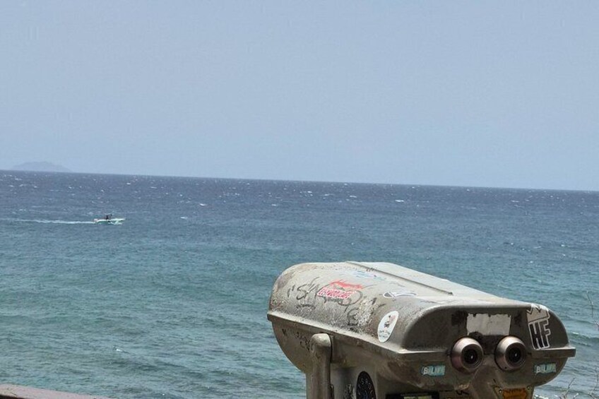 A body of water with a boat in the distance and a large, graffiti-covered structure in the foreground. 4
