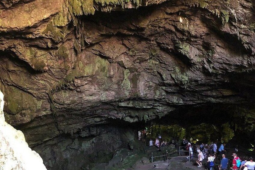 A cave entrance with a crowd of people. 5