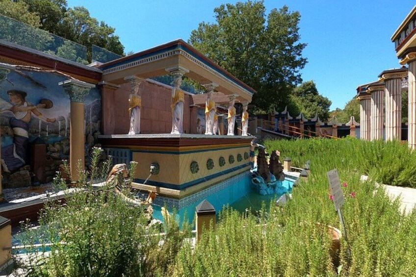 A building with classical architecture, a fountain, and a mural. 3