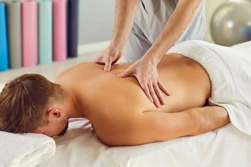 A person receiving a back massage on a massage table. 3