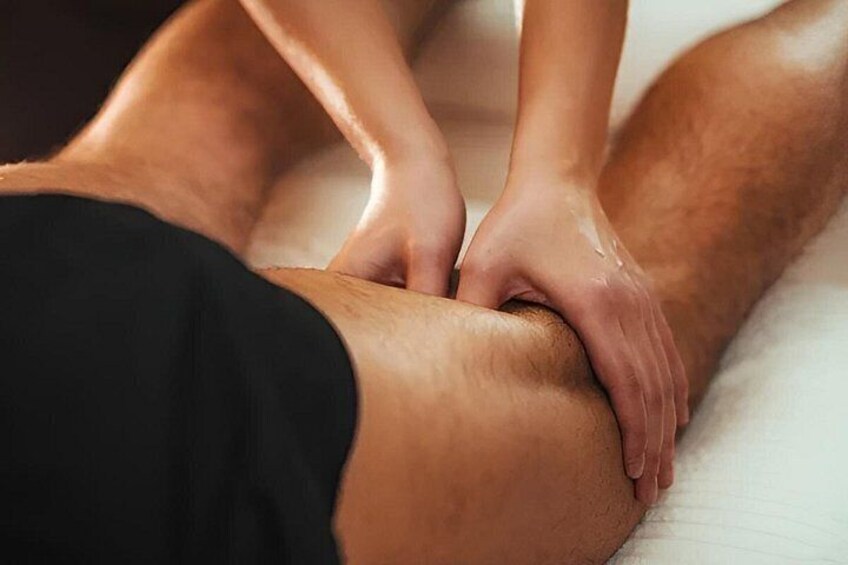 A person receiving a massage on their leg. 2