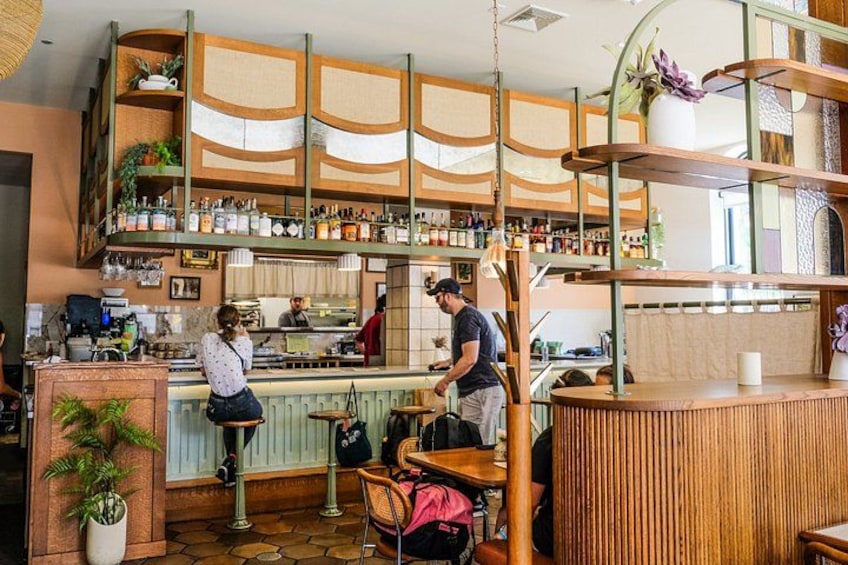A cafe interior with wooden shelves, a bar counter, and a seating area. 2