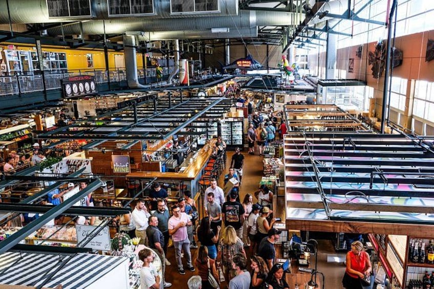 A bustling indoor market with various stalls and shoppers. 3
