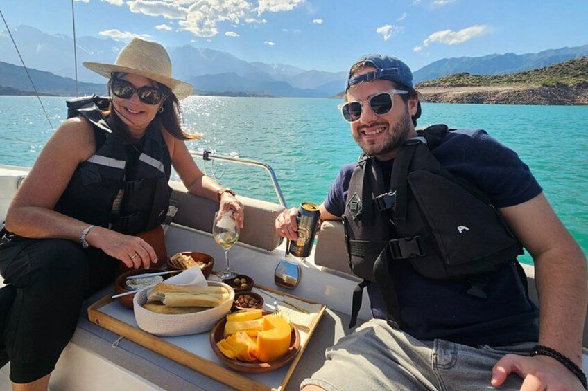 Two people on a boat with a tray of food and drinks. 4
