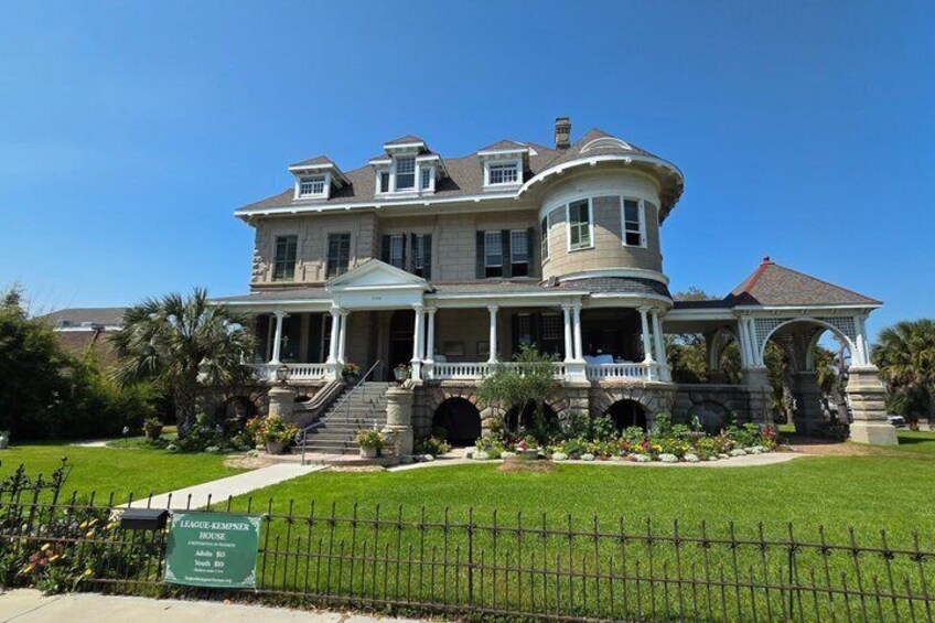 A large, historic house with a wrap-around porch, a gazebo, and a well-maintained lawn. 1