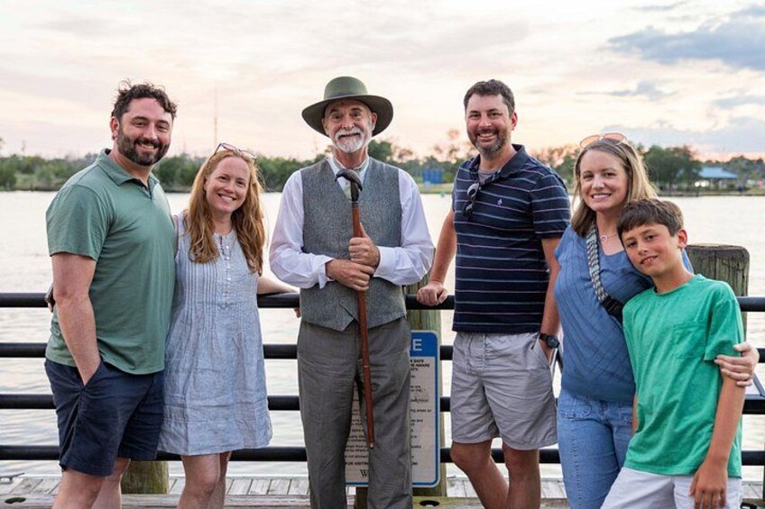 A group of people standing on a dock by a body of water. 5