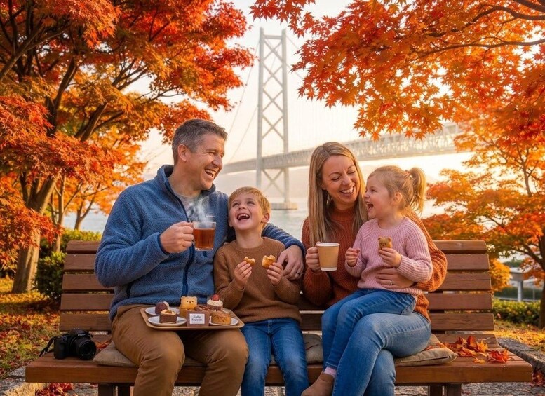 A family sitting on a bench with autumn leaves, a bridge, and a body of water in the background. 1