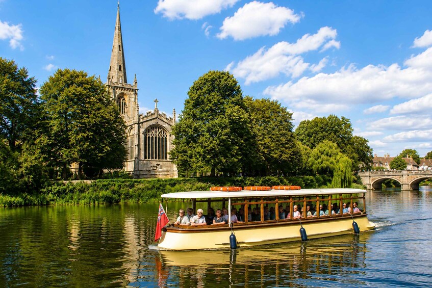 A riverboat with passengers, a church steeple, and a bridge in the background. 1