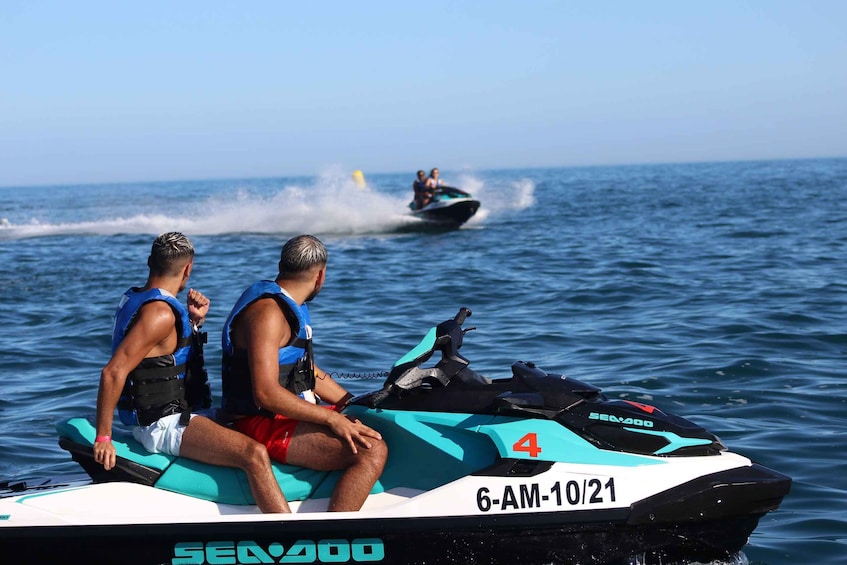 Two people on a Sea400 jet ski, with another jet ski creating a wake in the water. 1