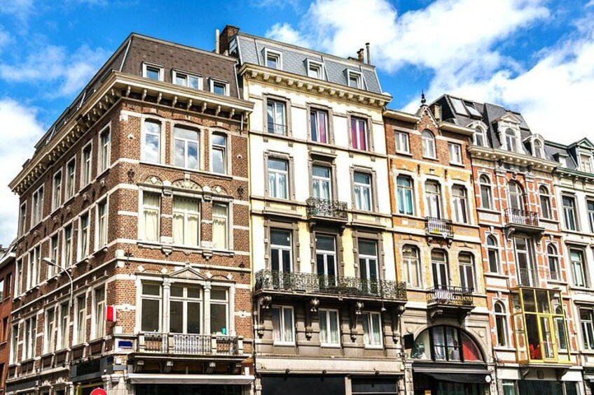 A row of historic European buildings with ornate facades and multiple stories. 3