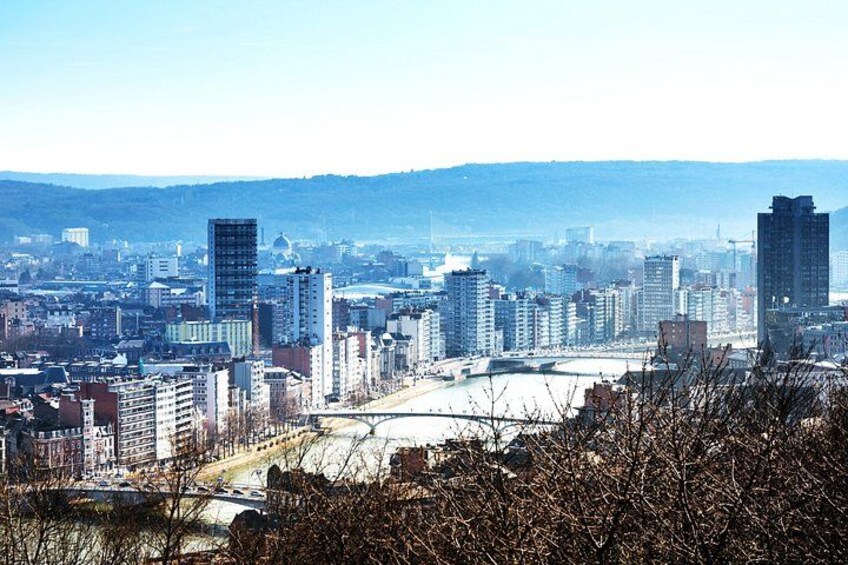 A cityscape with a river, buildings, and a hilly background. 2