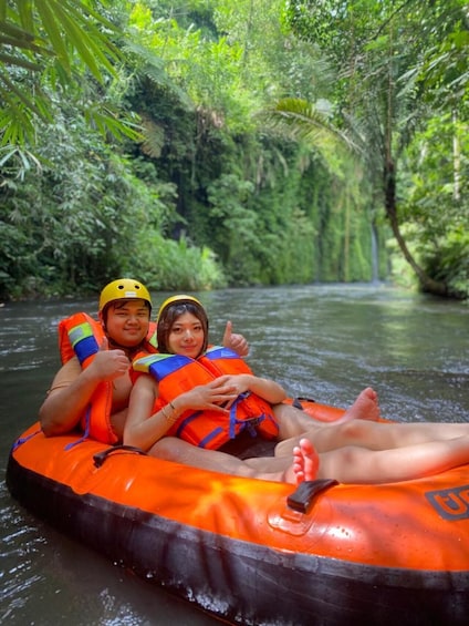 Dos personas en una balsa inflable en un río rodeado de abundante vegetación. 5