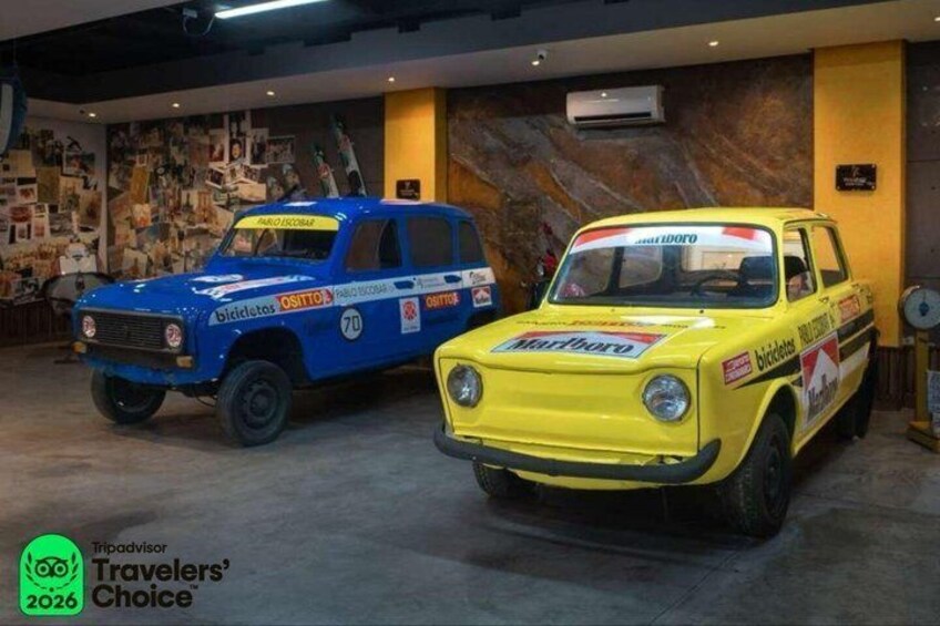 Two vintage racing cars displayed in an indoor setting. 2
