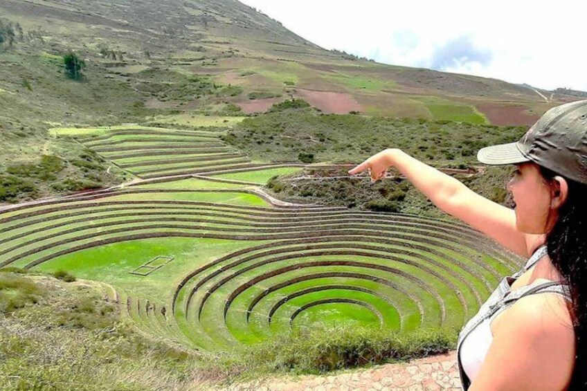 Terraced agricultural fields, a person pointing, and a hilly landscape. 3