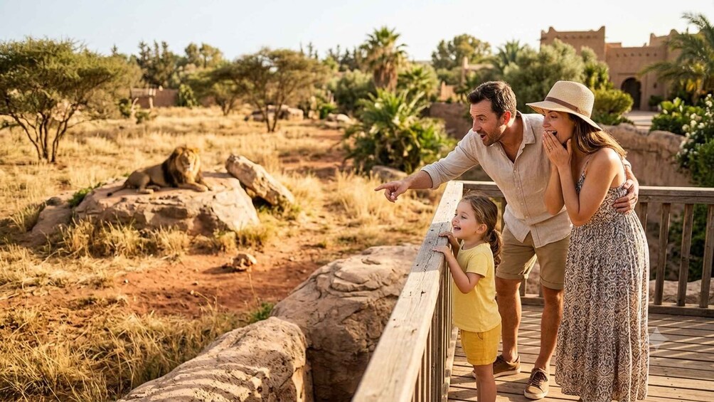 A family on a wooden bridge overlooking a savannah landscape with rocks and sparse trees. 2
