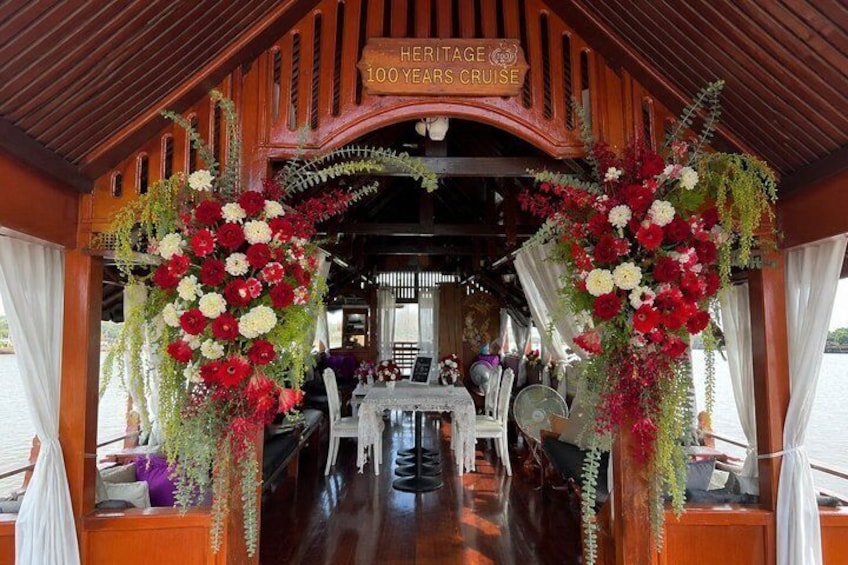 A dining area on a boat with a sign reading 'Heritage 100 Years Cruise.' 5