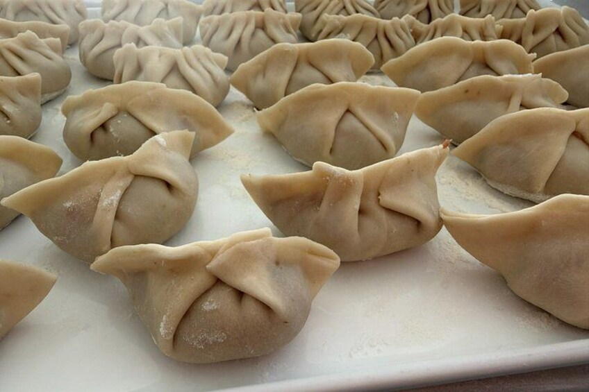 A tray of dumplings with a crimped edge design. 4