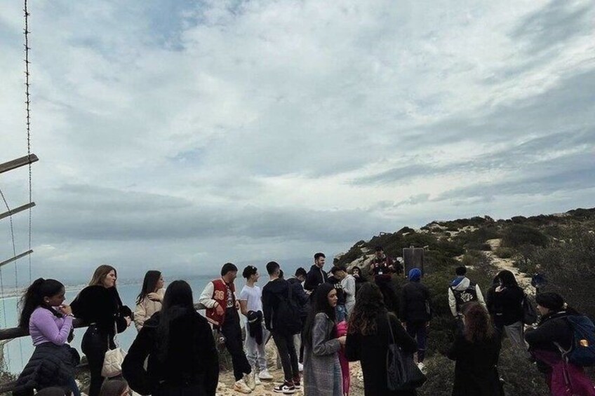 A group of people standing on a rocky path with a cloudy sky above. 2
