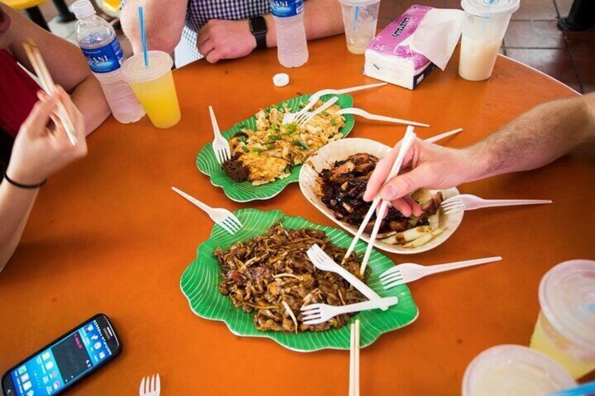 A group of people dining at a table with various dishes and drinks. 5
