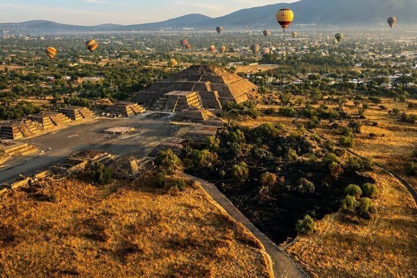 A landscape with pyramids and hot air balloons. 2