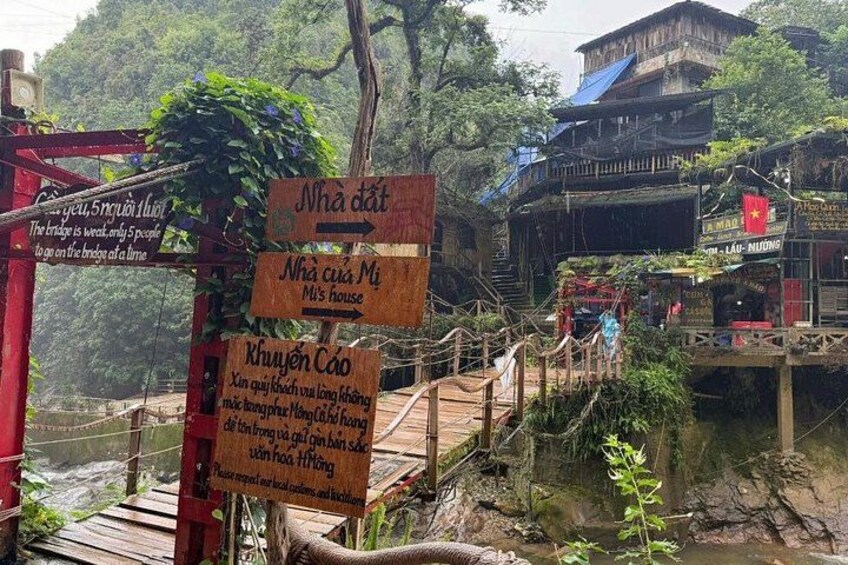 A wooden bridge with signs in a forested area. 5