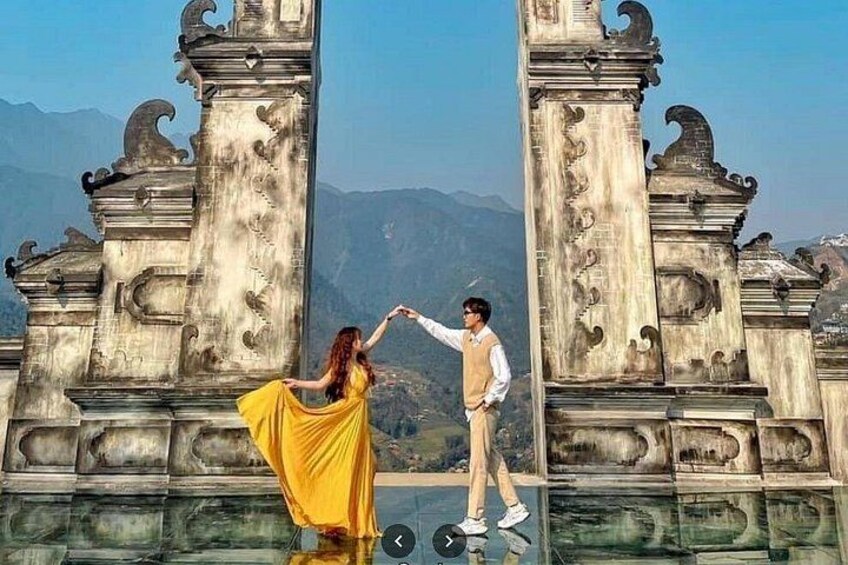 A person in a yellow dress standing on a reflective surface with a mountainous landscape in the background. 1