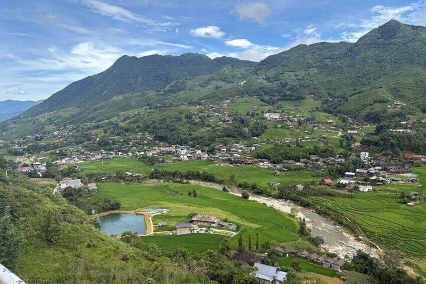 A mountainous landscape with a village, terraced fields, and a small body of water. 5