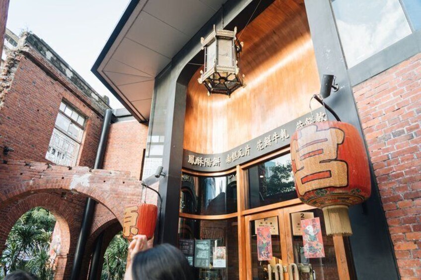 A traditional building with a wooden facade, a brick archway, and hanging lanterns. 5