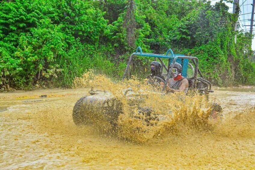 A vehicle driving through a muddy area with water splashing around. 1