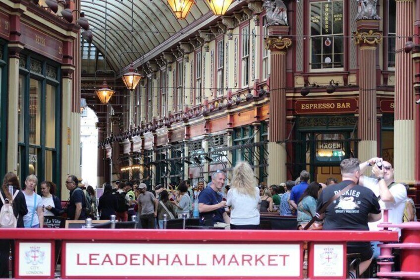A crowded indoor market with a red sign reading 'LEADENHALL MARKET.' 3