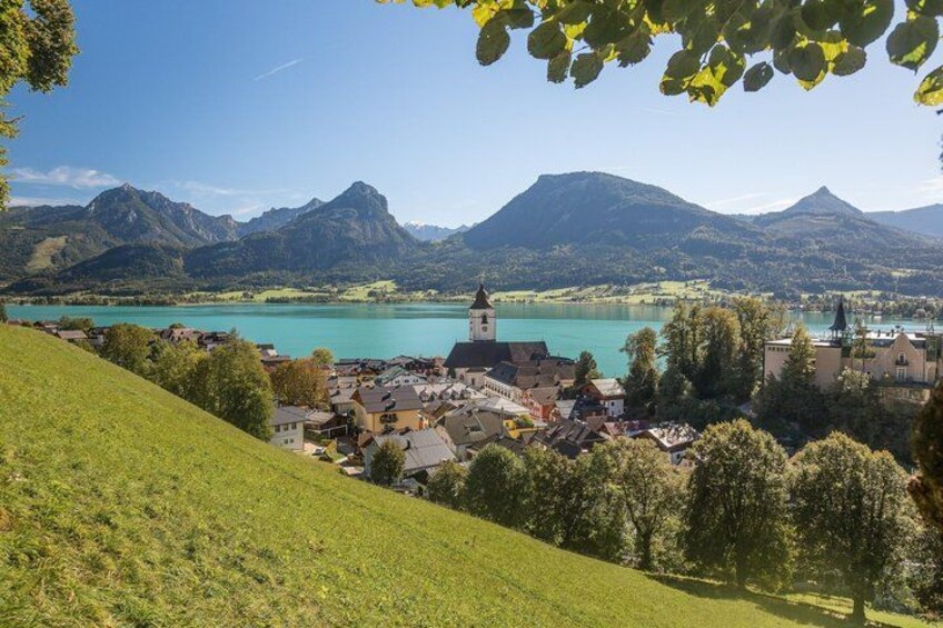 A town with a prominent church, a lake, and mountains in the background. 5
