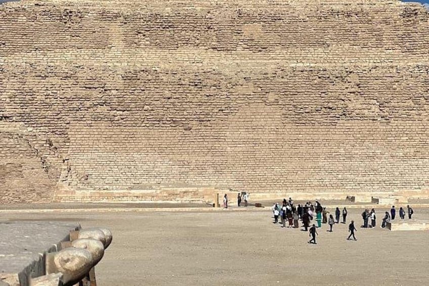 A large brick wall with people walking in front of it. 5