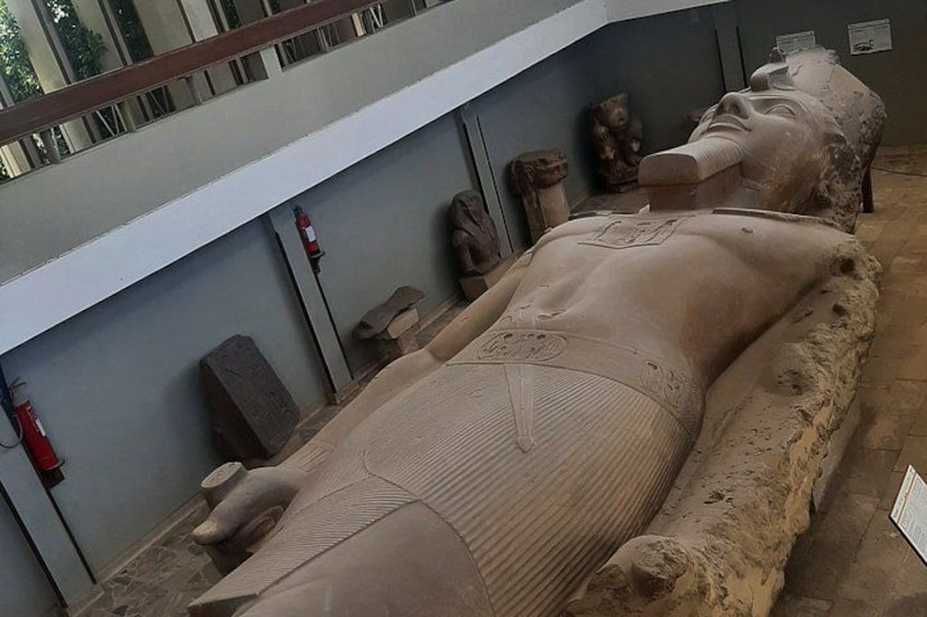 An ancient sarcophagus with hieroglyphics, placed on a stone platform in a museum. 3