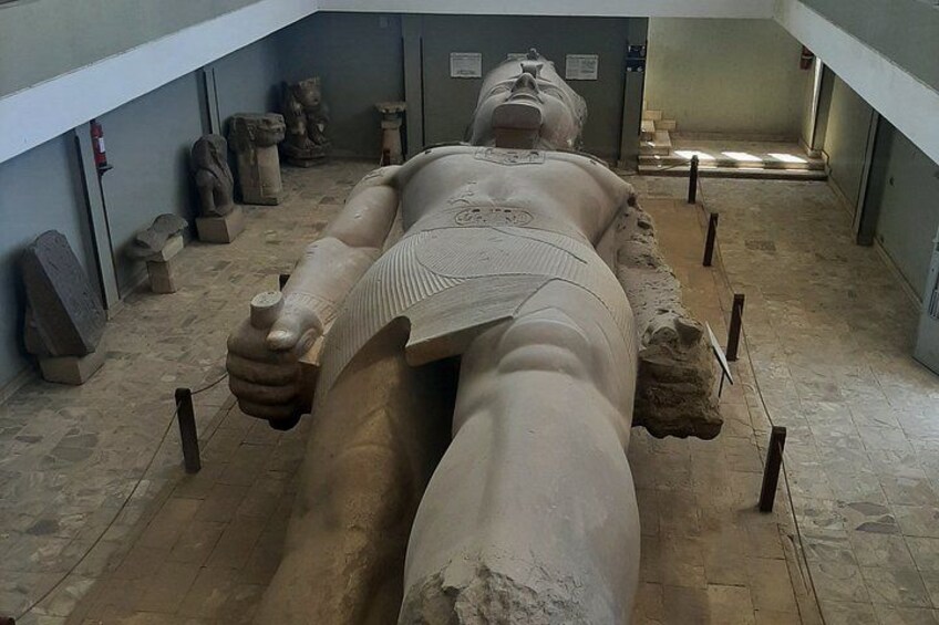 A large ancient Egyptian sarcophagus with hieroglyphics, surrounded by stone statues and artifacts in a museum setting. 4
